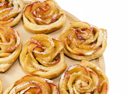 Sweet rolls with apples in the form of roses on wooden board on white isolated backgroundの写真素材