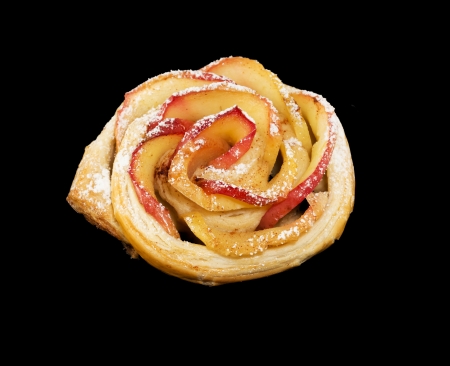 Sweet roll with apples in the form of roses on black isolated backgroundの写真素材