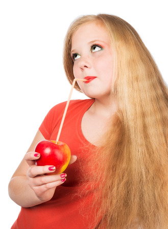 Attractive teen girl in the orange t-shirt holding an red apple in her hand  Face closeup over white isolated background の写真素材
