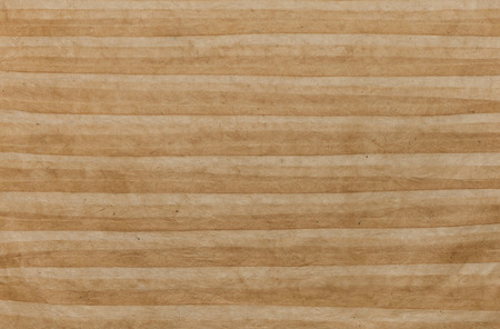 Texture of handmade striped rumpled paper sheet as backgroundの写真素材