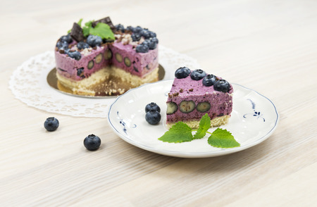 The piece of raw vegan blueberrycake decorated with melissa leavesの写真素材