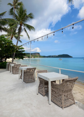 Tables and chairs on the beach in Koh Samui, Thailand. Ocean landscape as background.の写真素材