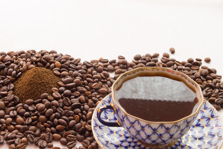 A cup of coffee, roasted coffee beans and ground coffeeの写真素材