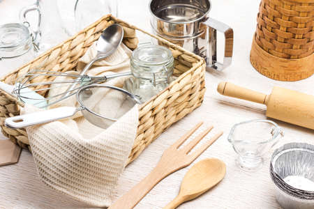 Glass jar, sieve and spoon in wicker box. Kitchen utensils for making dough. White background. Top viewの写真素材