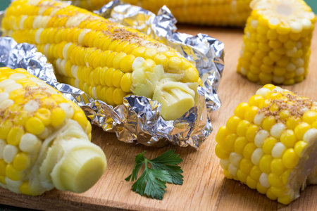 Boiled corn in foil on board. Close upの写真素材