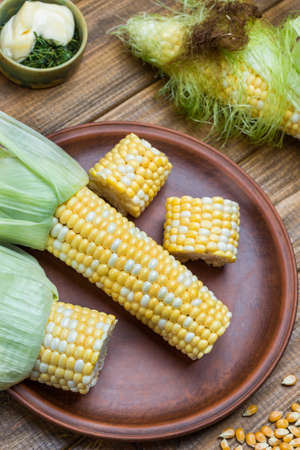 Sliced raw corn on plate. Wooden background. Flat layの写真素材