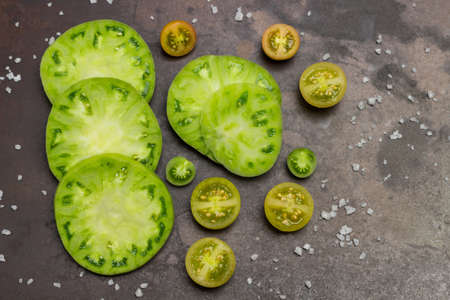 Sliced green tomatoes. Rusty metal background. Flat layの写真素材