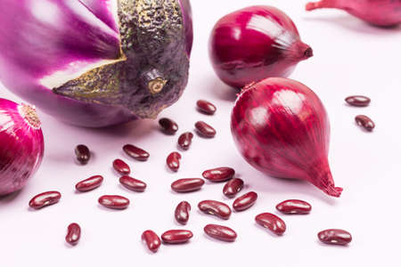 Purple eggplant, blue onions and beans on table. Close up. Top view. White backgroundの写真素材