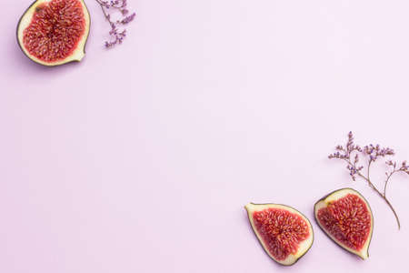 Fruit background. Halves of figs on sides of background. Pink background. Flat lay. Copy spaceの写真素材