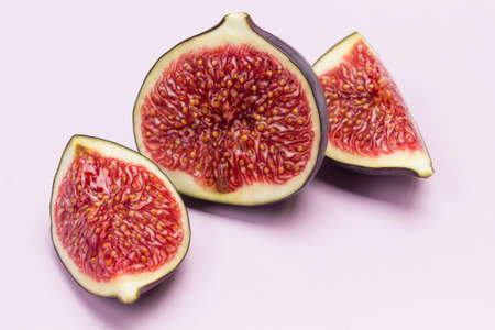Fig halves. Ripe fruit pulp. Close up. Pink background.の写真素材