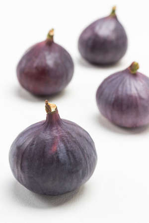 Four ripe purple figs. White background. Top viewの写真素材