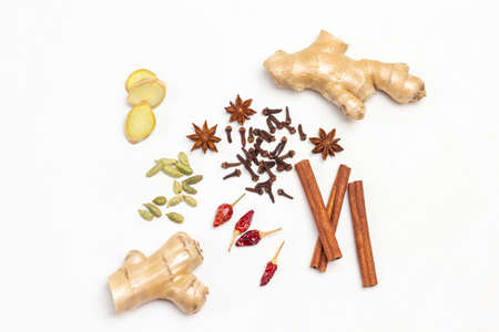 Alternative cold and flu remedy with cinnamon sticks, ginger root, cloves and star anise. White background. Flat lay. Copy spaceの写真素材