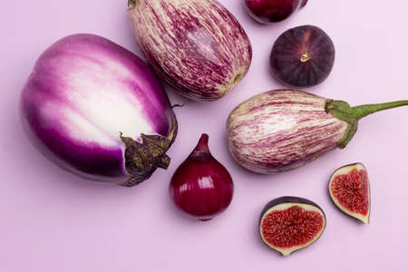 Eggplants, purple onions and figs on table. Pink background. Top view.の写真素材