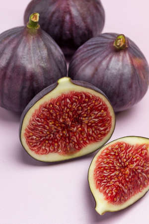 Two halves of fig and Whole purple figs. Ripe fruit pulp. Close up.の写真素材