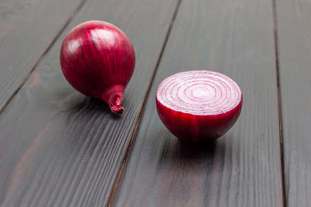 Half purple onion and whole onion. Dark wooden background. Top viewの写真素材