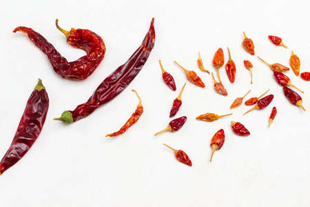 Three large dry red pepper pods and small pepper pods. White background. Top viewの写真素材