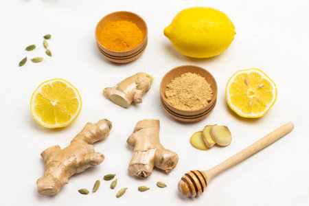 Ginger root and cardamom seeds. Dry ginger and turmeric in bowls, Lemon halves. White background....