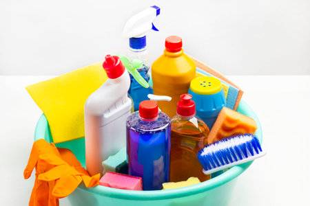 Set of household chemicals for cleaning the apartment in green plastic bowl. White background.の写真素材