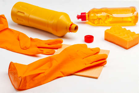 Orange rubber gloves, orange rag and orange plastic bottle. White background. Top viewの写真素材