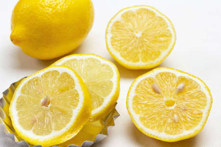 Lemon wedges and whole lemon close-up. White backgroundの写真素材