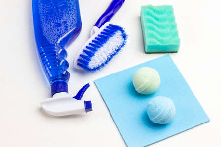 Spray blue bottle and brush. Two balls on blue rag. Green sponges. White background. Flat lay.の写真素材
