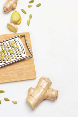 Ginger root and lemon on table. Grater with grated ginger. Copy space. Flat lay. White background.の写真素材