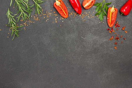Sliced red peppers and sprigs of rosemary along edge of background. Food Menu concept. Food background. Flat lay. Copy spaceの写真素材