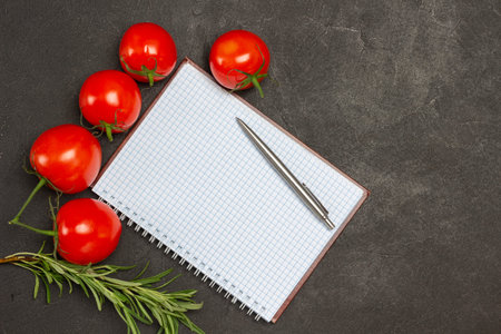 Clipboard with blank sheet and pen. Multicolored vegetables on table. Gray background. Flat lay. Copy spaceの写真素材