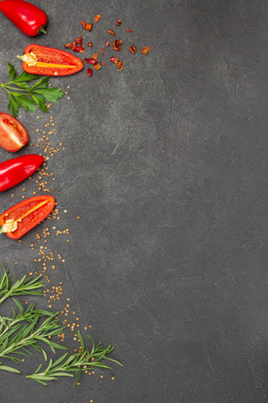 Sliced red peppers and sprigs of rosemary along edge of background. Food Menu concept. Food background. Flat lay. Copy spaceの写真素材