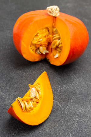 Orange pumpkin and pumpkin slice. Top view. Black backgroundの写真素材