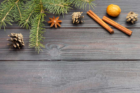 Pine branches and cones. Cinnamon sticks and nuts. New Year's still life. Copy space. Flat lay. Dark wooden background.の写真素材