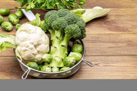 Cabbage in colander on wooden background. Fennel and parsley on table. copyspace. top viewの写真素材