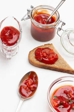 Tomato sauce on slice of bread. Sauce in jar and in bowl. white backgroundの写真素材