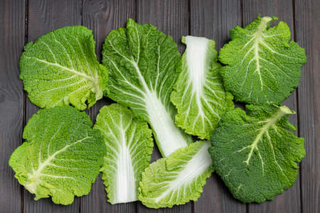 Green fresh Savoy cabbage leaves. flat lay. Dark wooden background.の写真素材