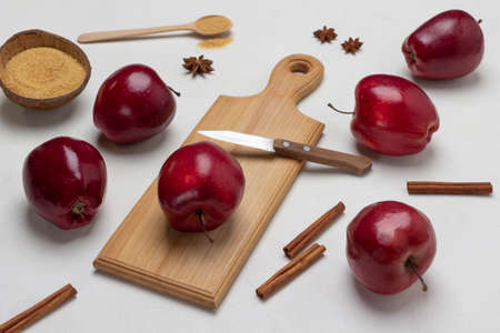 Ripe red apples and spices on table. Knife and apple on cutting board. top view. white backgroundの写真素材