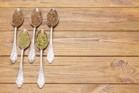 Set of dry spices in metal spoons. copyspace. flat lay. wooden backgroundの写真素材