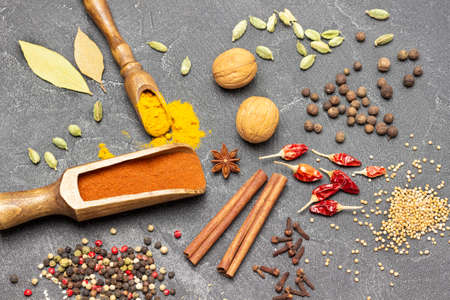 Walnuts, Ground paprika in bowl and scoop. Cinnamon sticks, red pepper pods and allspice. flat lay. black backgroundの写真素材