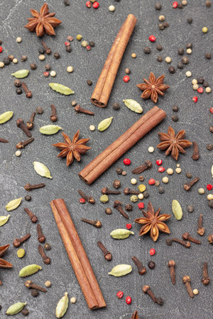 Spices on black background. Cardamom, allspice, cinnamon sticks, star anise and cloves. flat layの写真素材