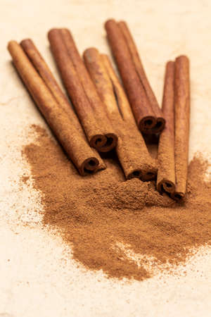 Ground cinnamon and cinnamon sticks on the table. top view. brown background.の写真素材