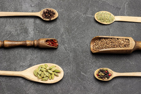 Dry spices in wooden spoons. flat lay. black backgroundの写真素材