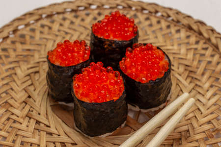 Nori maki with caviar and chopsticks on wicker plate. top view.の写真素材