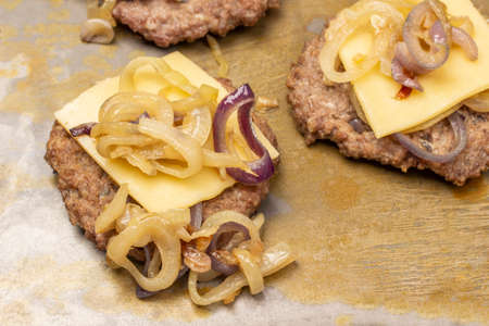 Fried burger with cheese and fried onions. Rusty background. top view.の写真素材