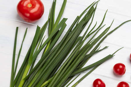 Tomatoes and green onions on a white background. top viewの写真素材
