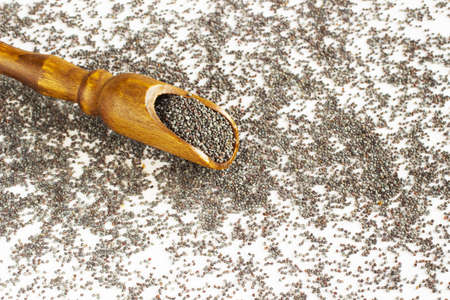 wooden spoon lie on poppy grainsの写真素材