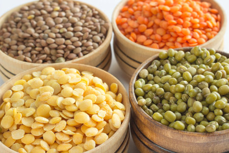 Four varieties of lentils in wooden bowls