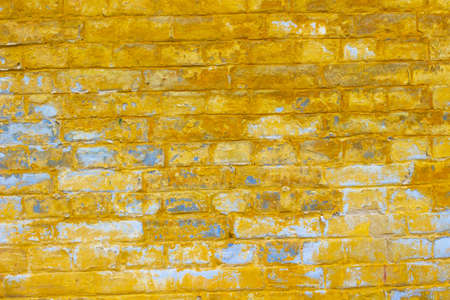 Wall made of bricks. Traces of old yellow paintの写真素材