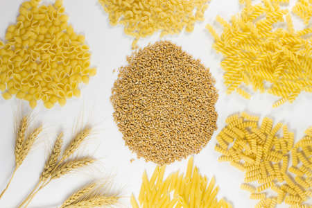 different kinds of pasta. Grains of wheat and wheat spikelets. top view. white backgroundの写真素材