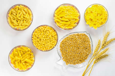 Five types of pasta in glass plates. Grains of wheat and wheat spikeletsの写真素材