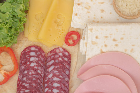 Tortilla and ingredients for her meat, tomatoes, rice, corn, peppers, tomato sauceの写真素材