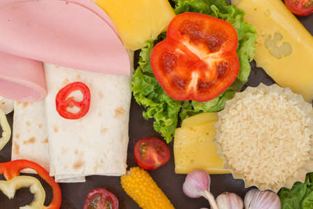 Tortilla and ingredients for her meat, tomatoes, rice, corn, peppers, tomato sauceの写真素材